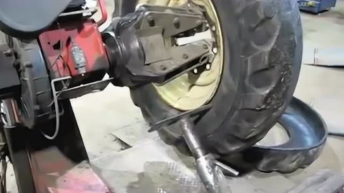 國外修車廠給拖拉機更換外胎的拆胎操作